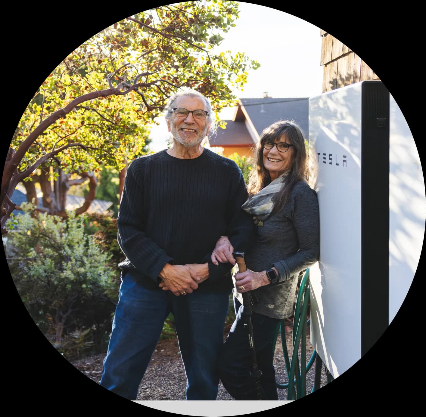 Two homeowners standing next to their SGIP-funded home battery
